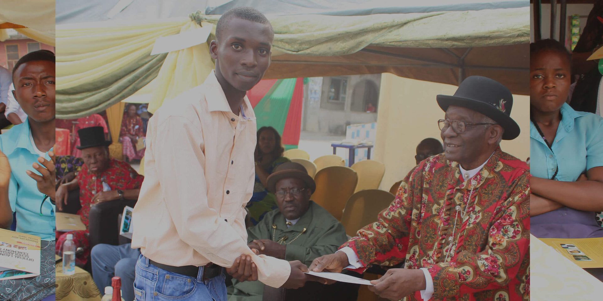 An awardee receiving his scholarship from the Founder
